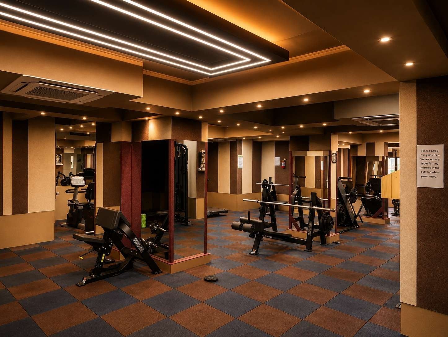 Gymnasium with strength machines, chequered rubber flooring and striped wall panels